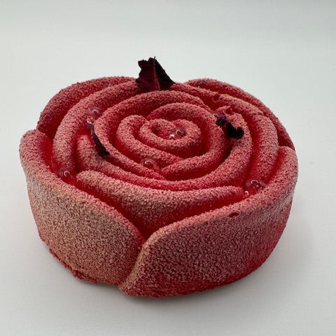 "Elegant rose-shaped entremet with tangy raspberry mousse, nutty pistachio sponge, and a ruby chocolate crunch base—balancing freshness, richness, and texture."