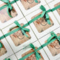Gift boxes with green ribbons arranged on a tiled surface