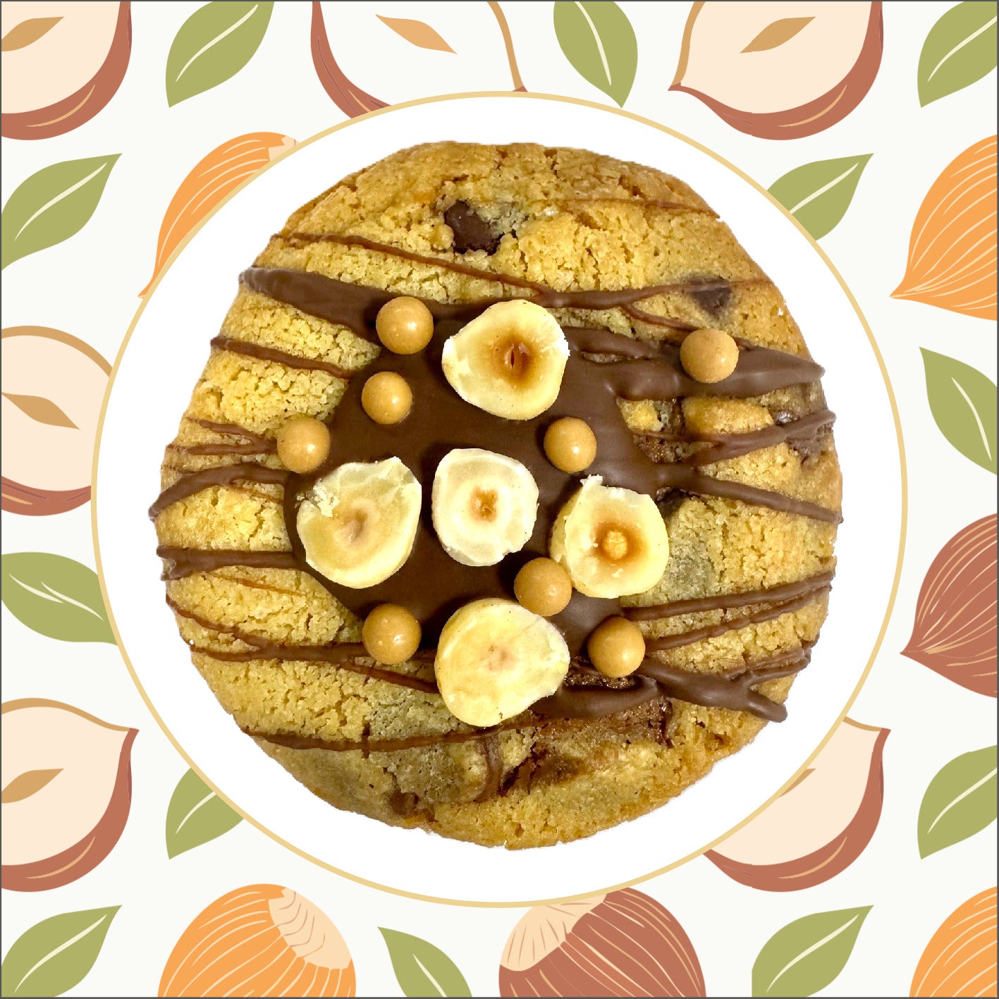 "Handcrafted cookie with a soft chocolate chip base, filled with creamy hazelnut gianduja, and topped with chocolate drizzle, roasted hazelnuts, and golden caramel crispy balls."